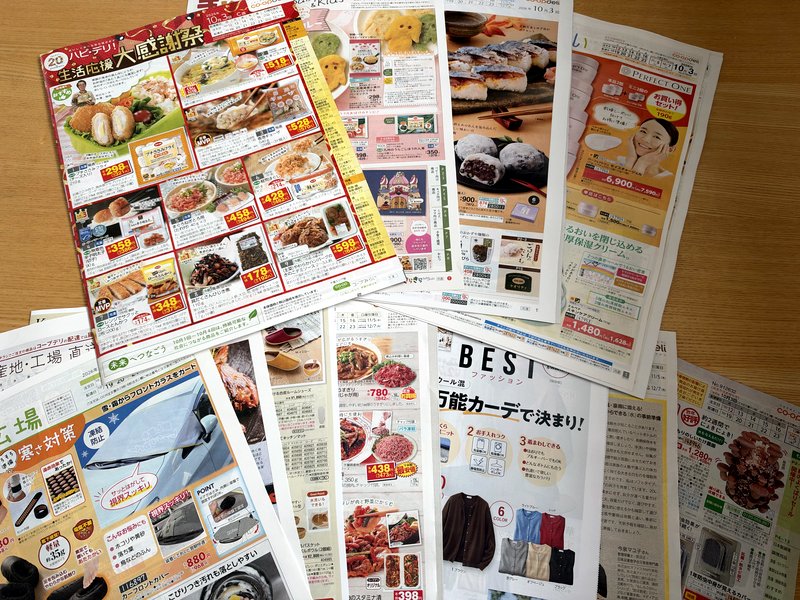 コープデリのカタログが複数冊積み重なっている様子